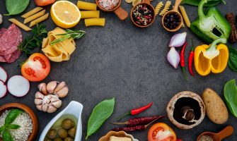 Italian food cooking ingredients basil, parmesan cheese ,garlic, olive oil , pine nut ,peppercorn and himalayan salt on dark stone background  flat lay and copy space.